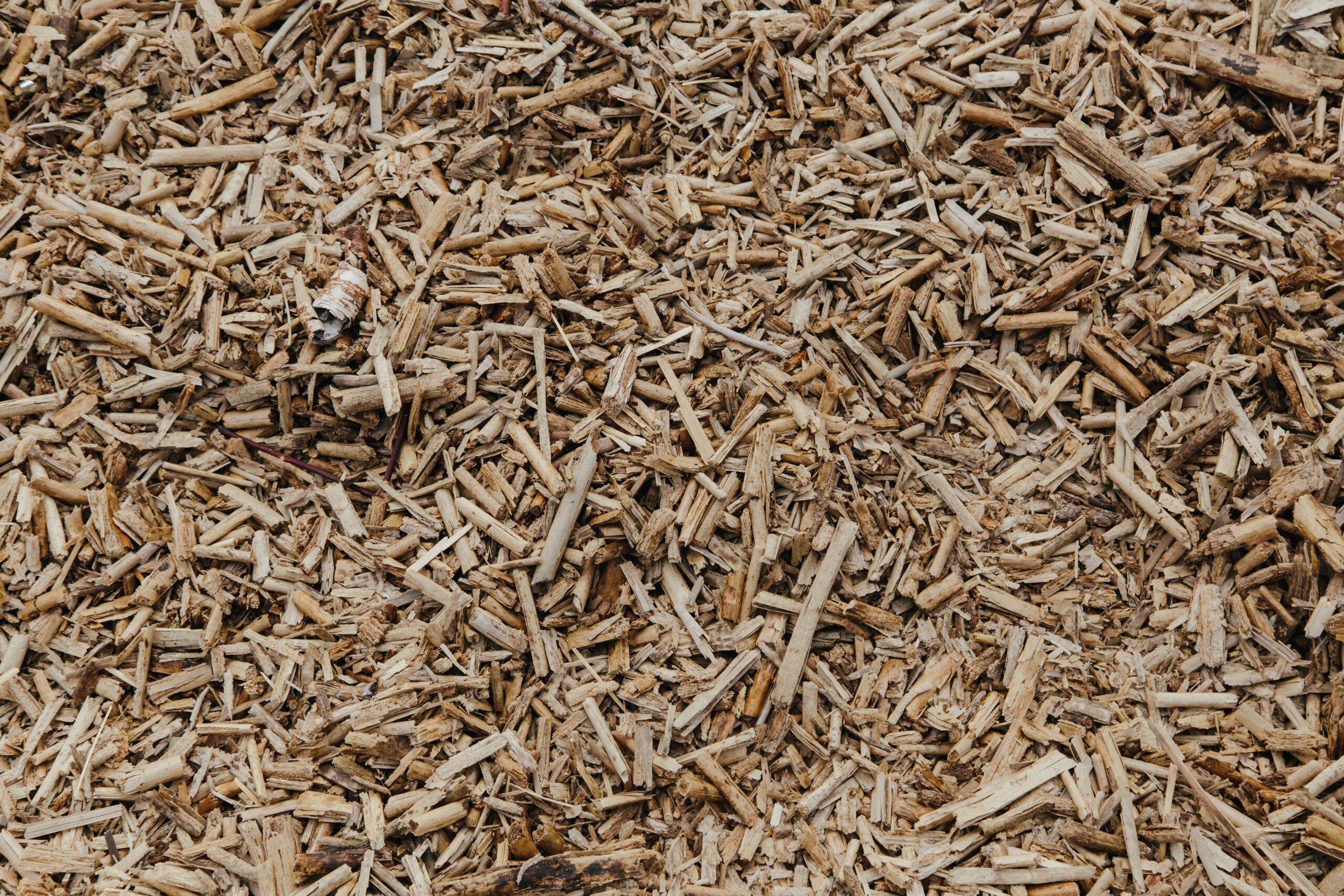 Close-up view of a textured surface of natural brown wood chips, ideal for organic and environmental themes.